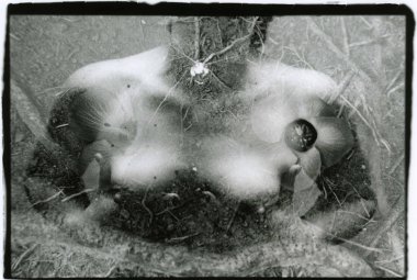 Bir kadın çıplak göğüslerini elleriyle tutar..