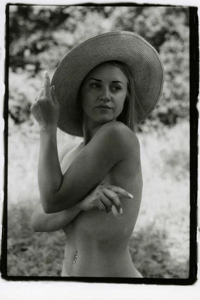 Mujer desnuda delgada en un sombrero y un ombligo perforado . Imágenes de stock libres de derechos