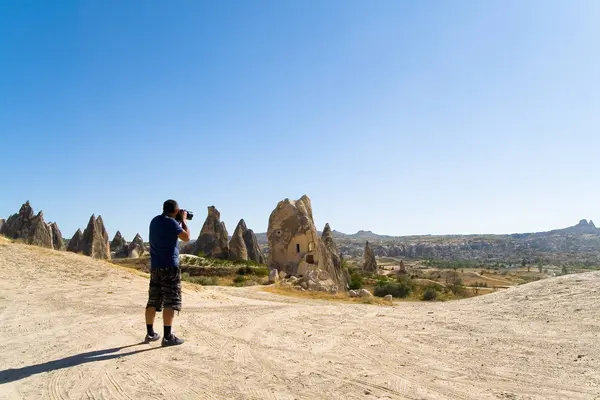 Un hombre fotografía el inusual paisaje montañoso de Capadocia . — Foto de Stock