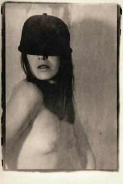 Üstsüz kızın yüzü başlık ile gizlenmiş..