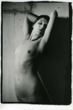 Sıska, güzel, çıplak esmer duvar kenarında..