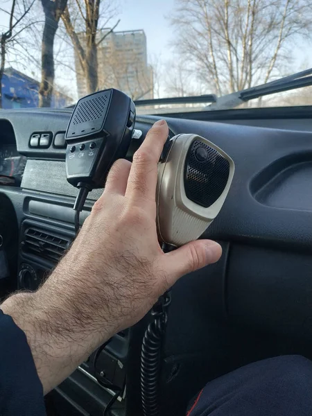 La mano di un poliziotto tiene la tangente di una stazione radio . — Foto Stock