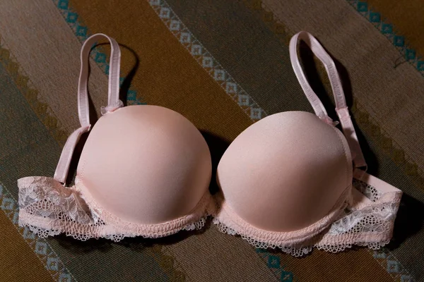 A female bra lies on the bedspread. 免版税图库图片