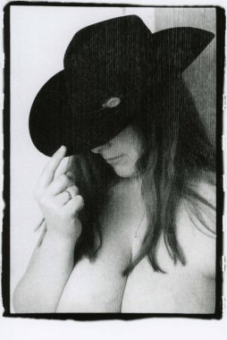 Çıplak göğüslü, şapkalı şişman bir kadın..