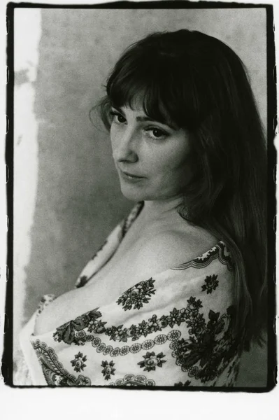 Yarı çıplak, iri göğüslü şişman bir kadın, omuzlarında bir eşarp.