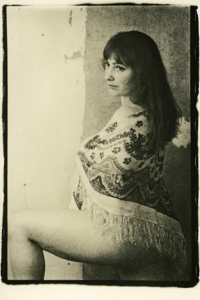 Omzunda atkısı olan yarı çıplak bir kadın..