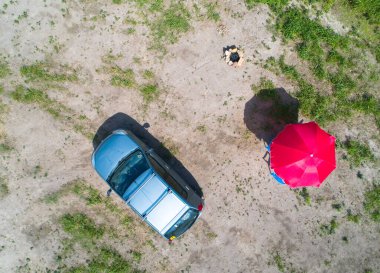 Araba manzarası, taştan yapılmış barbekü ve yazın güneş şemsiyesi. Kamp fotoğrafçılığı..