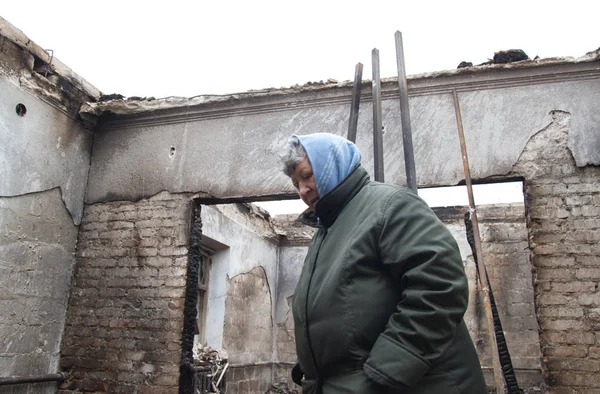 MARIUPOL, UKRAINE JANUARY 25, 2016: Жінка стоїть у його будинку зруйнований мінометом — стокове фото