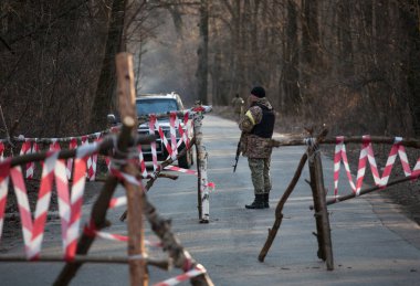 KYIV, UKRAINE MARTH 26, 2016: Ukraine soldier patrolling territory near checkpoint  clipart
