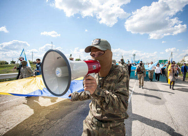 CHONHAR, UKRAINE AUGUST 20, 2016: Activist screams in loudspeaker during rally near Crimean border