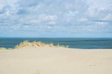 Kum kıyı ve deniz altında Litvanya, Curonian Spit, Nida dune bulutlara.