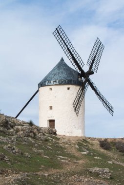 Beyaz eski yel değirmeni Consuegra (Castilla La Mancha, İspanya), yakınlarındaki tepe üzerinde bölge sembolü ve Don Kişot (Alonso Quijano) seyahat bulutlu gün.