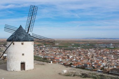 Old white windmill at a viewpoint on the hill near Consuegra (Castilla La Mancha, Spain), a symbol of region and journeys of Don Quixote (Alonso Quijano). clipart