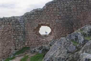 Beyaz eski yel değirmeni Consuegra (Castilla La Mancha, İspanya), yakınlarındaki tepe üzerinde bölge ve Don Kişot (Alonso Quijano) seyahat ve bulutlu gün, duvardaki bir delikten bir görünüm için bir şehir sembolü.
