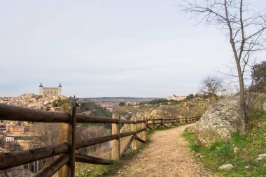 Bir yol hill vith Toledo Alcazar, görünümüne üzerine Toledo, Castilla la Mancha, İspanya'nın çevresi akşam.