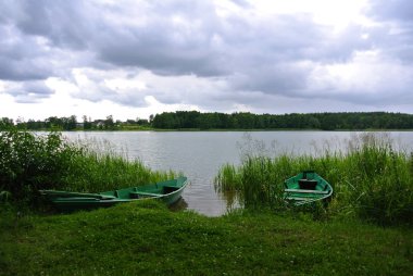 Trakai doğal park, bir göl, orman ve yeşil balıkçı tekneleri, Litvanya görünümüne yağmurlu gün.