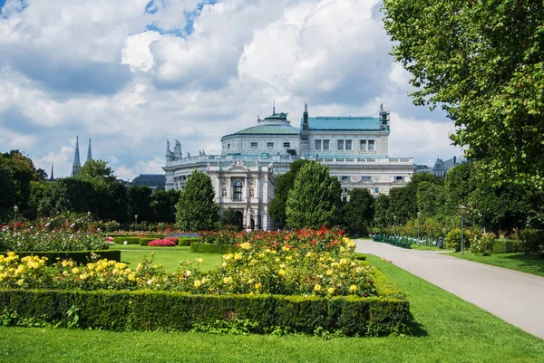 Vídeň, Rakousko - 29. červenec 2016: Pohled parku Volksgarten s kvetoucí červené a žluté růže před Hofburg, Vídeň, Rakousko. — Stock fotografie