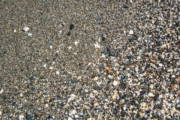 Close-up van strand met kleine steentjes, zand en schelpen in Malaga, Andalusie, Spanje. — Stockfoto