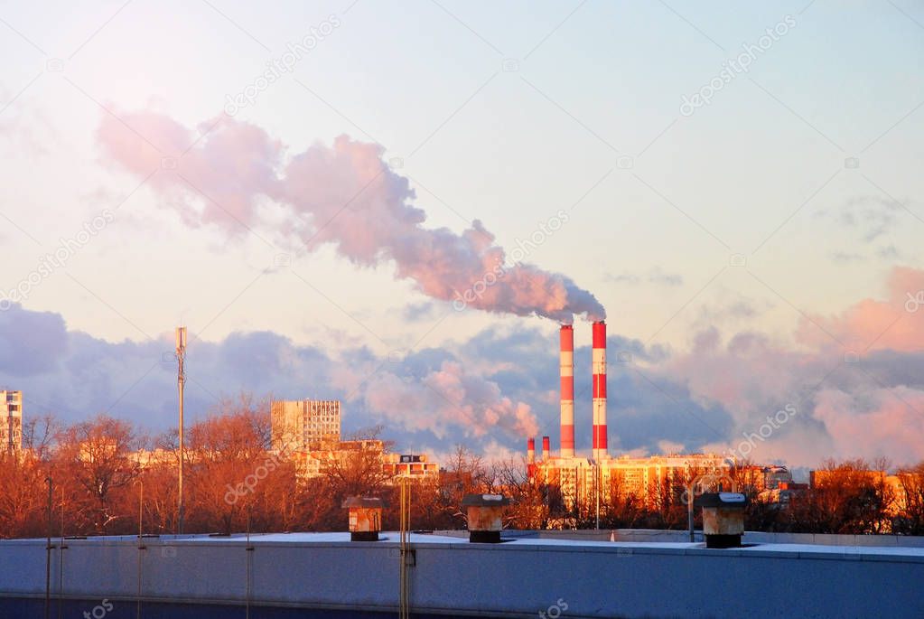 Early morning with down sun light, a view to the industrial landscape of the city with smoke emissions from chimneys, Moscow, Russia.