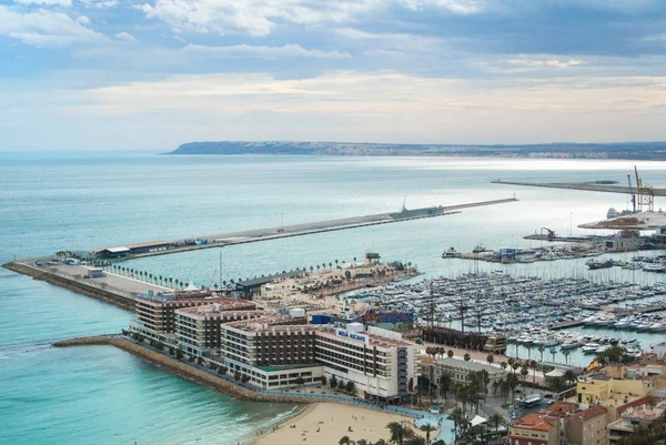 ALICANTE, ESPANHA - FEVEREIRO 12, 2016: Vista do Castelo de Santa Bárbara para um porto da cidade com muitos iates, para os telhados dos edifícios e para o mar Mediterrâneo em dia nublado, Alicante, Espanha . — Fotografia de Stock