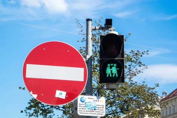 Wien, Österrike - 29 juli 2016: En närbild av ett grönt trafikljus med en bild av två promenader lesbisk flickor vid center i Wien, Österrike. — Stockfoto