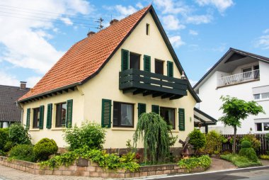 Walldorf, Almanya - 4 Haziran 2017: Kiremit çatı ve yeşil bir bahçe Alman Köyü'nde bir konut ev.