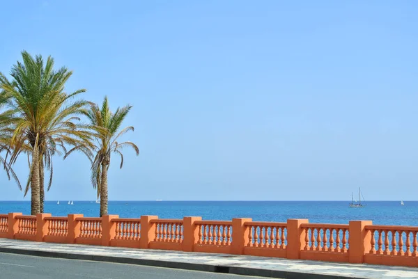 Uma vista para o mar Mediterrâneo a partir de um passeio marítimo da praia de Benalmadena e uma estrada com palmeiras no forefround, província de Málaga, Andaluzia, Espanha . — Fotografia de Stock