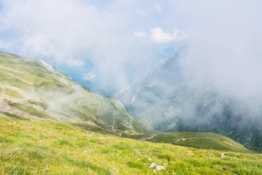 Panoramik Carpatian dağlar, serpantin yol ve arka plan, Bucegi doğal park, Romanya, güneşli yaz gününde, büyük sis bulutu içinde.