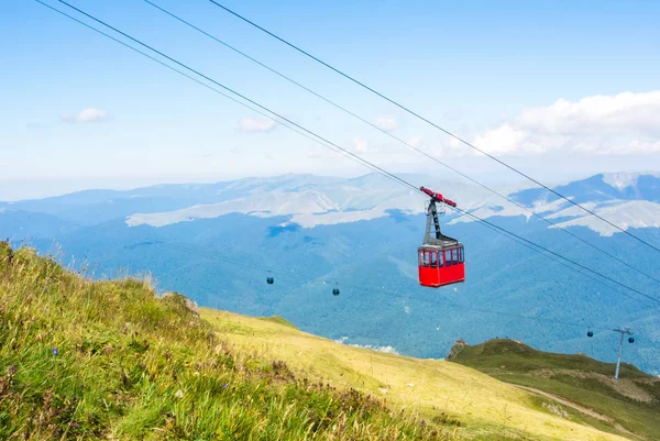 Uma vista para cabine aberta vermelha sobre o topo da montanha e belas paisagens com montanhas azuis, vala verde, parque natural de Bucegi, Sinaia, Romênia . — Fotografia de Stock