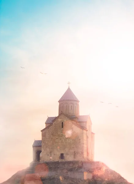 Iglesia ortodox georgiana sobre la colina temprano en la mañana, aves voladoras y rayos de sol, abstracto inspirador tonificado consepto de la religión, la oración, el culto y el cristianismo . —  Fotos de Stock
