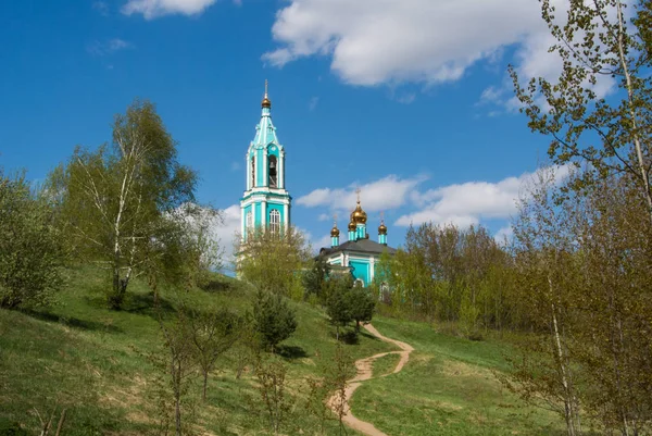 Kyrkliga syn på små rysk ortodox kyrka över kullen, vackra sommarlandskap med träd och en sökväg, Moskva, Ryssland. — Stockfoto