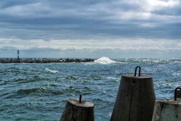 Ένα ανάχωμα της Βαλτικής θάλασσας στην πόλη Μπαλτιίσκ σε συννεφιασμένη καλοκαιρινή μέρα, θέα σε έναν χαφιέ, κύματα και μεγάλα πέτρινα τουβλάκια στην προβλήτα, το πιο δυτικό σημείο της Ρωσίας, την περιοχή του Καλίνινγκραντ. — Φωτογραφία Αρχείου
