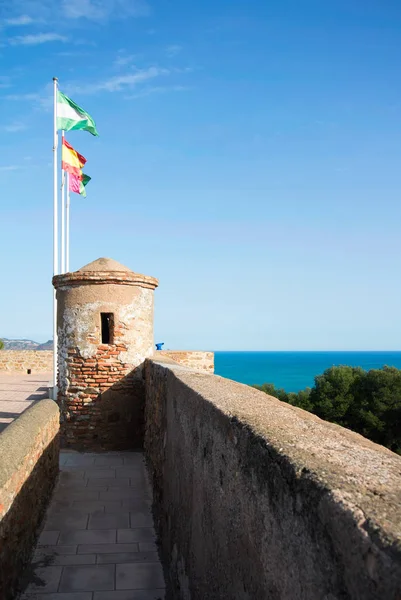 Bright colorful flags over the tover of an ancient stone wall of