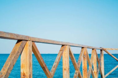 Parlak turuncu kahverengi ahşap çit ve t bir mavi denize yakın çekim