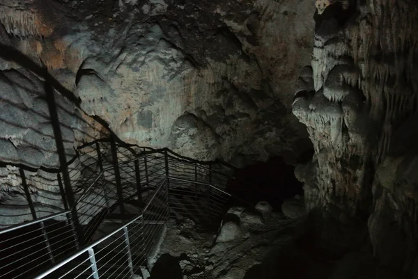 Escalera que se adentra profundamente en la cueva, hermoso formato iluminado — Foto de Stock