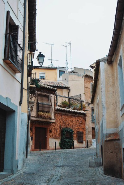 Old narrow medieval street of Toledo, vintage houses with lanter