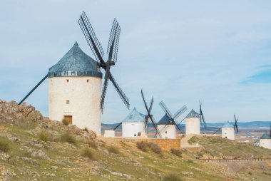 Rows of old white traditional windmills on the hill near Consueg clipart