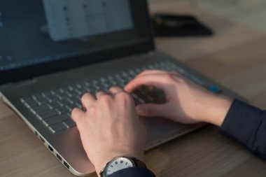 Tipik bir dizüstü bilgisayar klavye üzerinde eller. İşyerinde çalışan adam