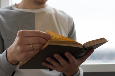 Kitap okumak bir adam elinde tutan