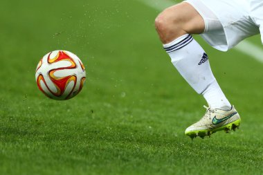 Bir bacak ve ayak futbolcu beyaz çorap ve ayakkabı çalıştıran ve top toz su sıçraması ile yeşil çim sahada oynamak ile top sürme, Avrupa Ligi ikinci bacak maç Dinamo arasında açık gri kapatın