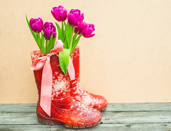 Buquê de tulipas em botas de borracha — Fotografia de Stock