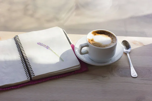 Spring inspiration. Coffee with notebook and rays of sun and ide