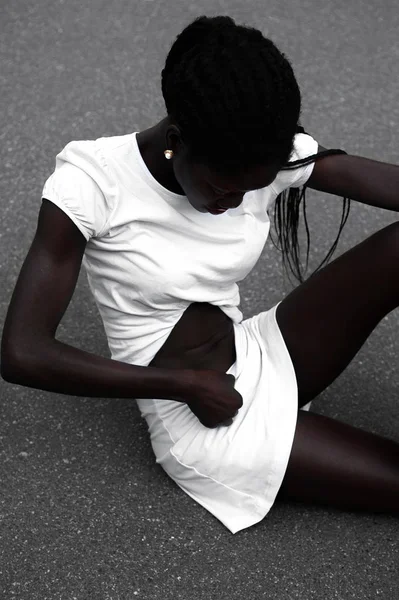 Giovane modello afro-americano sportivo in bianco guardando abs — Foto Stock