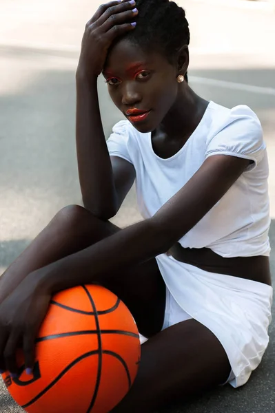 Молодая афро-американская девушка с творческим макияжем и баскетболом Стоковое Фото
