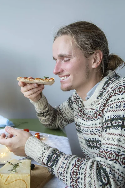 Handsome guy eating christmas pizza — Stock Photo, Image