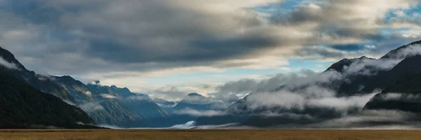 Eglinton dalen öppna vyn med gräsmark i förgrunden längs vägen av milford road i Nya Zeeland. — Stockfoto