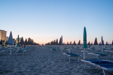 Sabah güneşi ıssız Beach'te. Şafak vasıl belgili tanımlık kıyı. Boş şezlong. İnsanlar olmadan Beach.