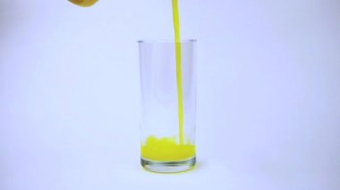 Şeffaf cam beyaz zemin üzerine dökülen sarı turuncu yavaş süreci.