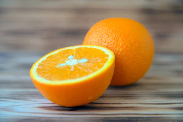 Sliced orange orange orange on wooden background macro photo.