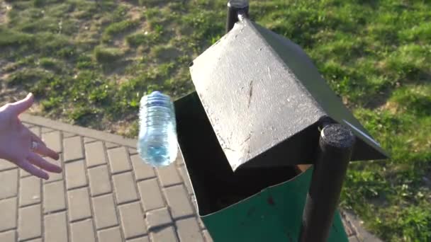 Frauenhand wirft leere Plastikflasche in den Mülleimer — Stockvideo
